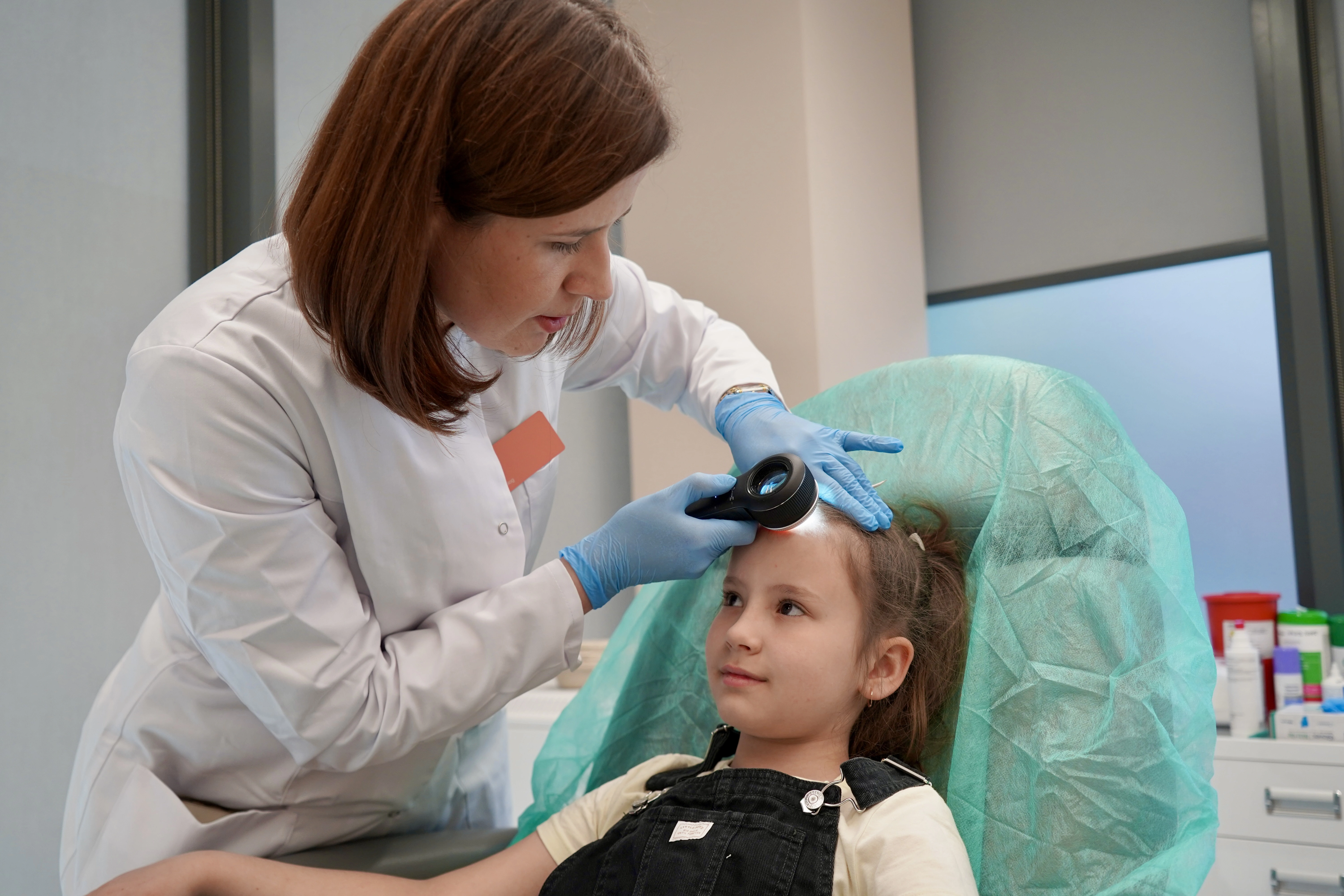 Dermatolog dziecięcy przeprowadza diagnostykę skóry głowy u dziecka
